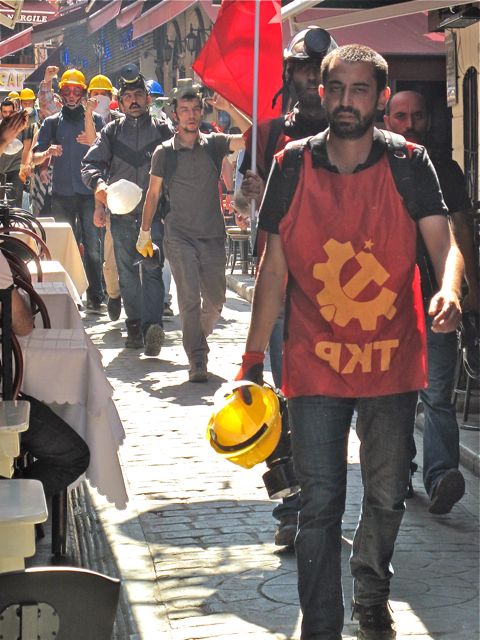 A tough column of protestors from the Turkish Communist Party moves through Nevizadeh restaurant street after a confrontation with police.