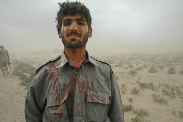 "I survived" - Afghan soldier standing to attention after a suicide bombing nearby. Photo by Graeme Smith